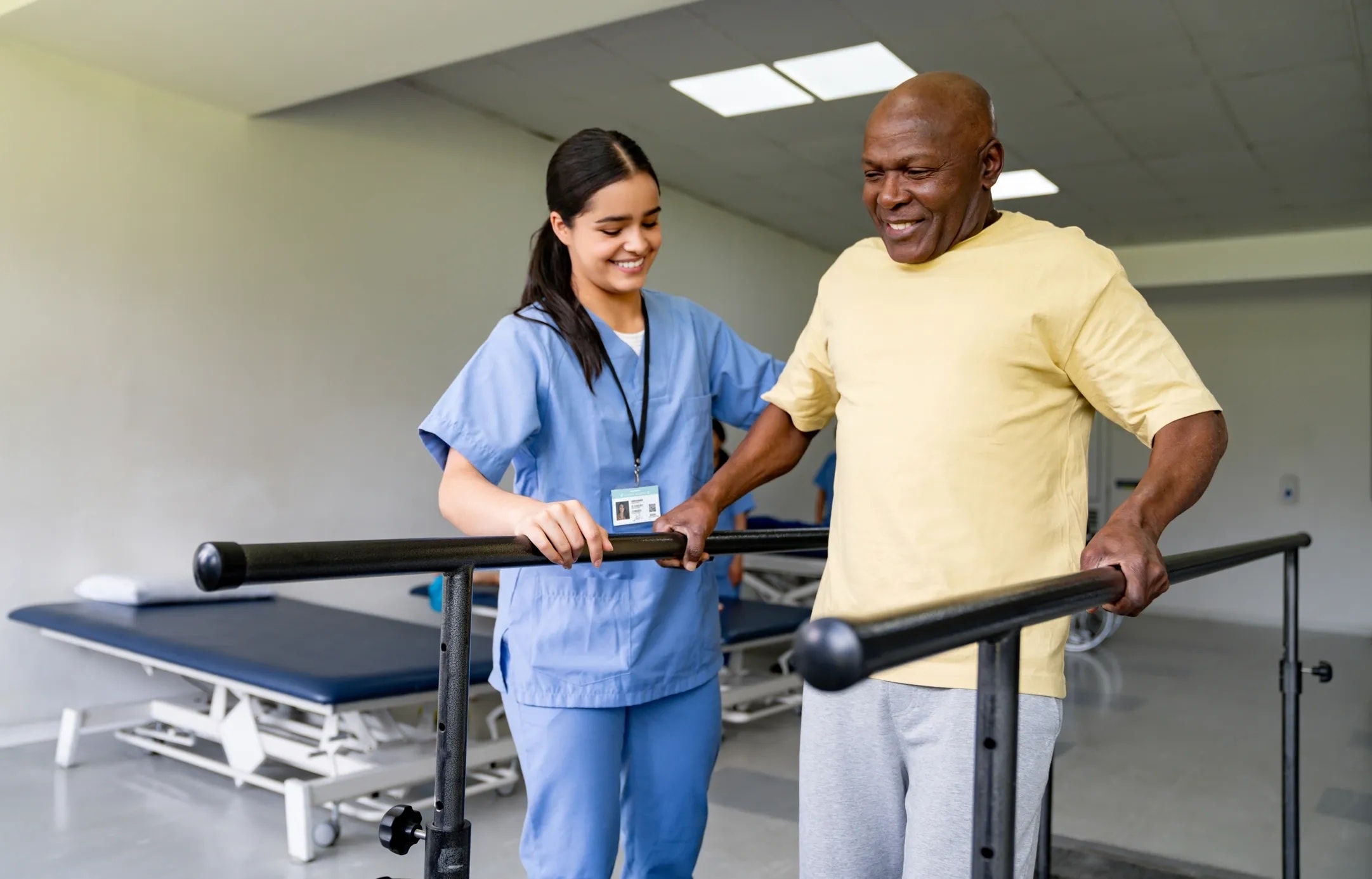 Physical therapist helping elderly patient stand and regain mobility